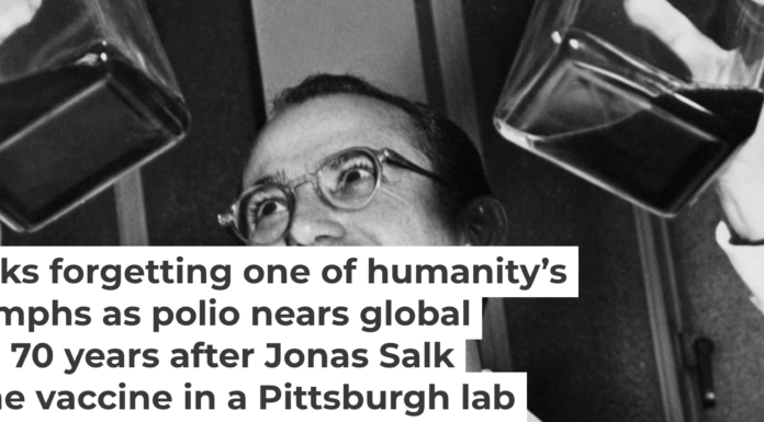 Dr. Jonas Salk displays his polio vaccine, which he developed in a University of Pittsburgh laboratory. Bettmann/Bettmann Collection via Getty Images